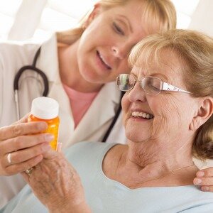 Doctor with patient looking at pill bottle