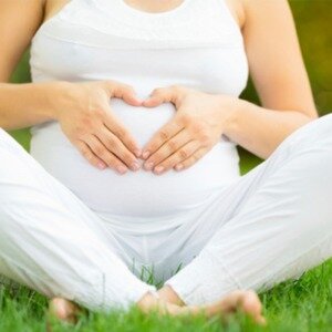 pregnant woman with heart hands